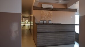 Uma mesa de recepção com design moderno, um ventilador de teto e um ar condicionado fixado na parede.