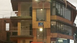 Um edifício de vários andares com uma placa grande de 'DIMAR' no topo.
