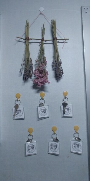 A wall with dried flowers and keychains.