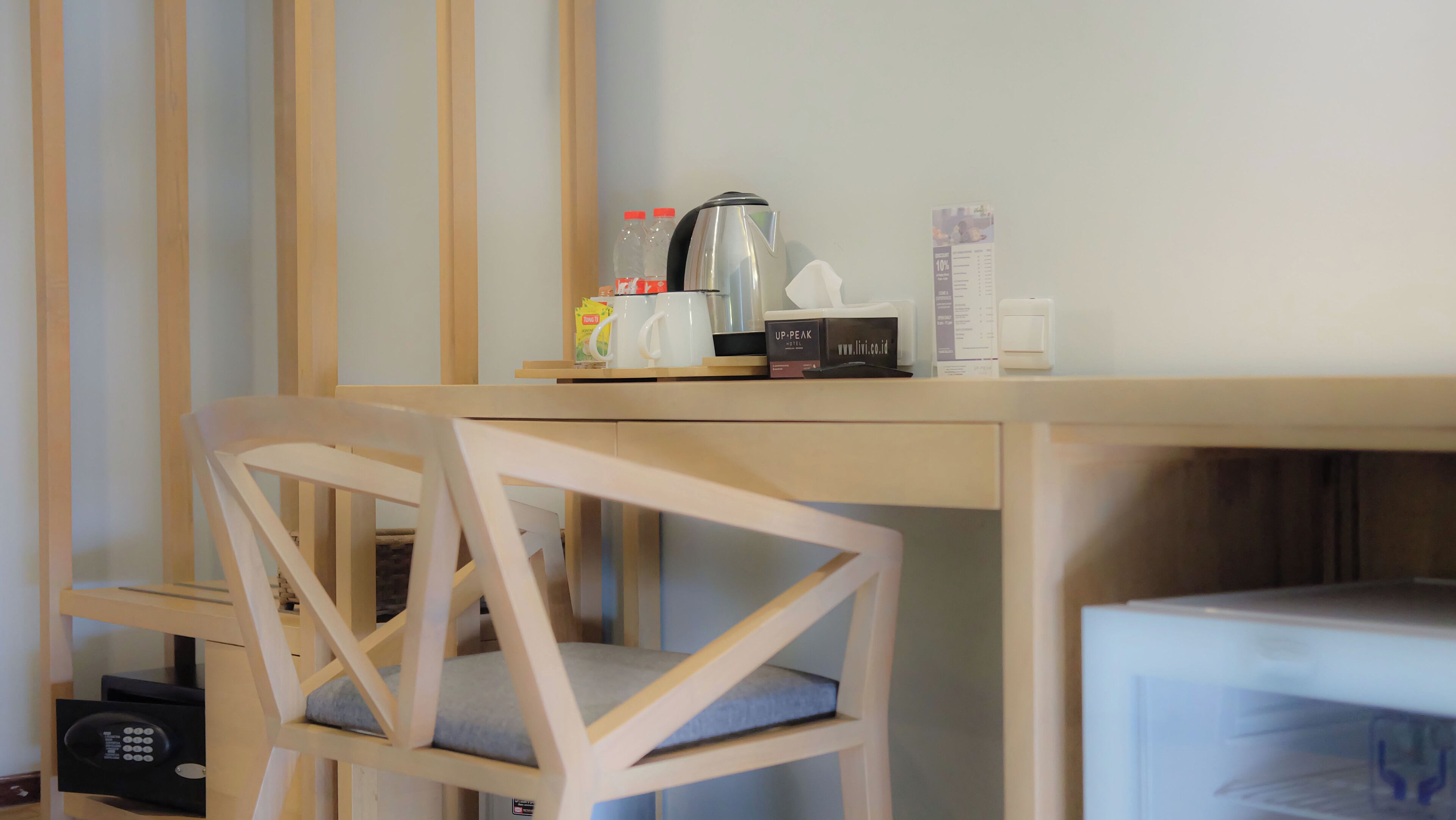 A wooden desk with a kettle, a box, and a menu.