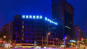 A hotel with illuminated signage, a prominent building facade, and surrounding urban street lighting. - Hollyston Hotel of Chengdu (Chengdu)