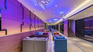 A modern lounge area with seating and a staircase. - Hollyston Hotel of Chengdu (Chengdu)