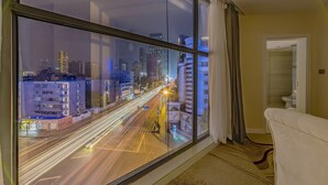 A room with a large window overlooking a city street at night, featuring light trails from moving vehicles. - Hollyston Hotel of Chengdu (Chengdu)