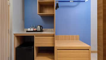 A compact kitchenette with a countertop, a sink, and a coffee maker.