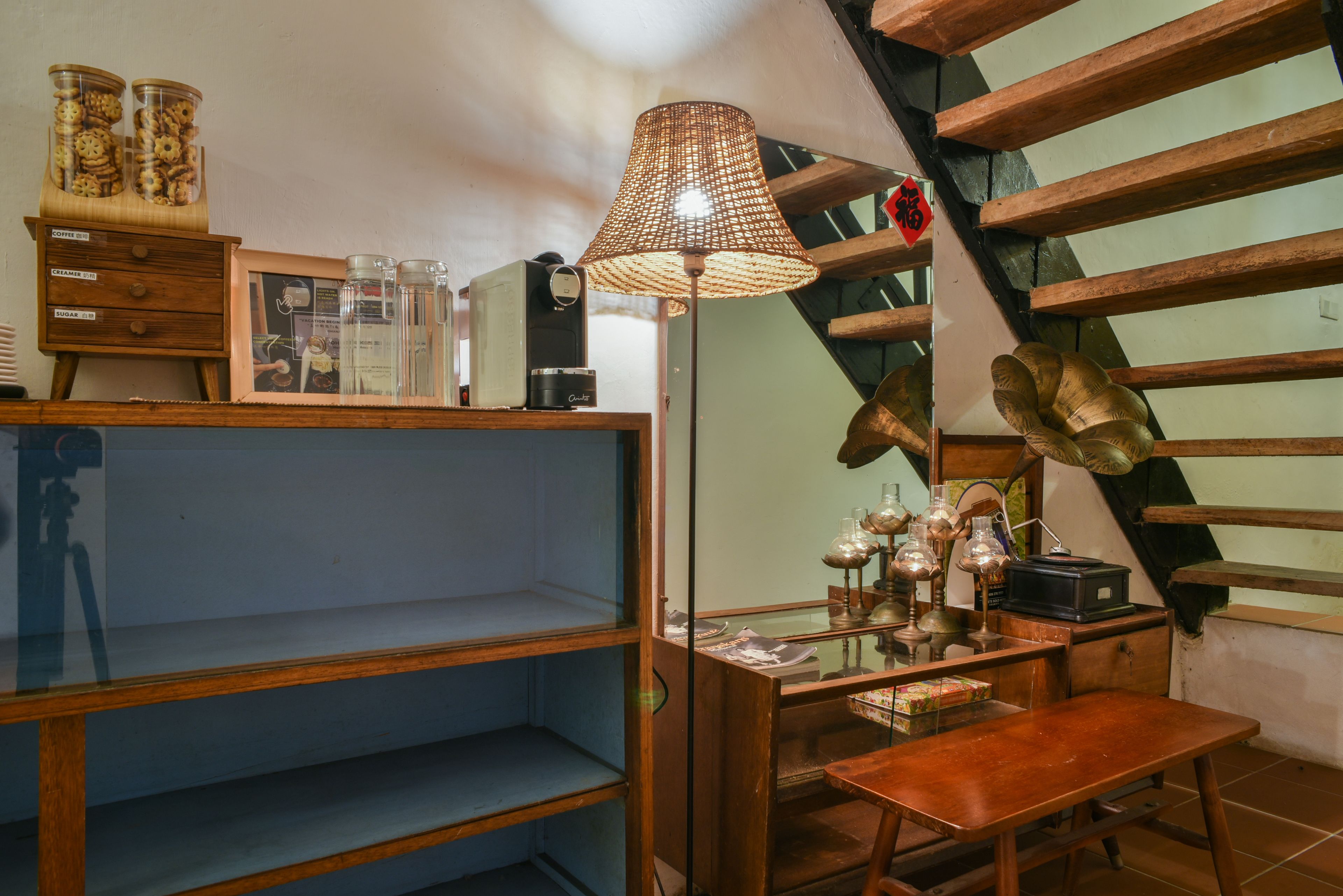 Een gezellige kamer met een houten bureau, planken, een lamp en een trap.