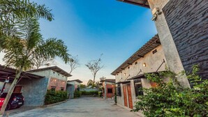A courtyard with buildings, a parked car, and a clear sky. - Paradiso Boutique Resort (Trat)