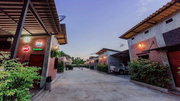 A street view of a residential area with houses, a parked truck, and a Heineken sign. - Paradiso Boutique Resort (Trat)