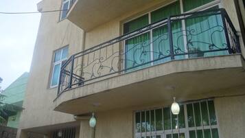 Un edificio de varios pisos con balcones, ventanas amplias y una puerta visible.
