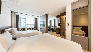A hotel room with two beds, a desk, a TV, and a bathroom with a mirror. - CS Premier Hotel Seoul (Seoul)