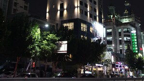 A tall hotel with illuminated windows and a sign indicating it is open for the Grand Opening. - CS Premier Hotel Seoul (Seoul)