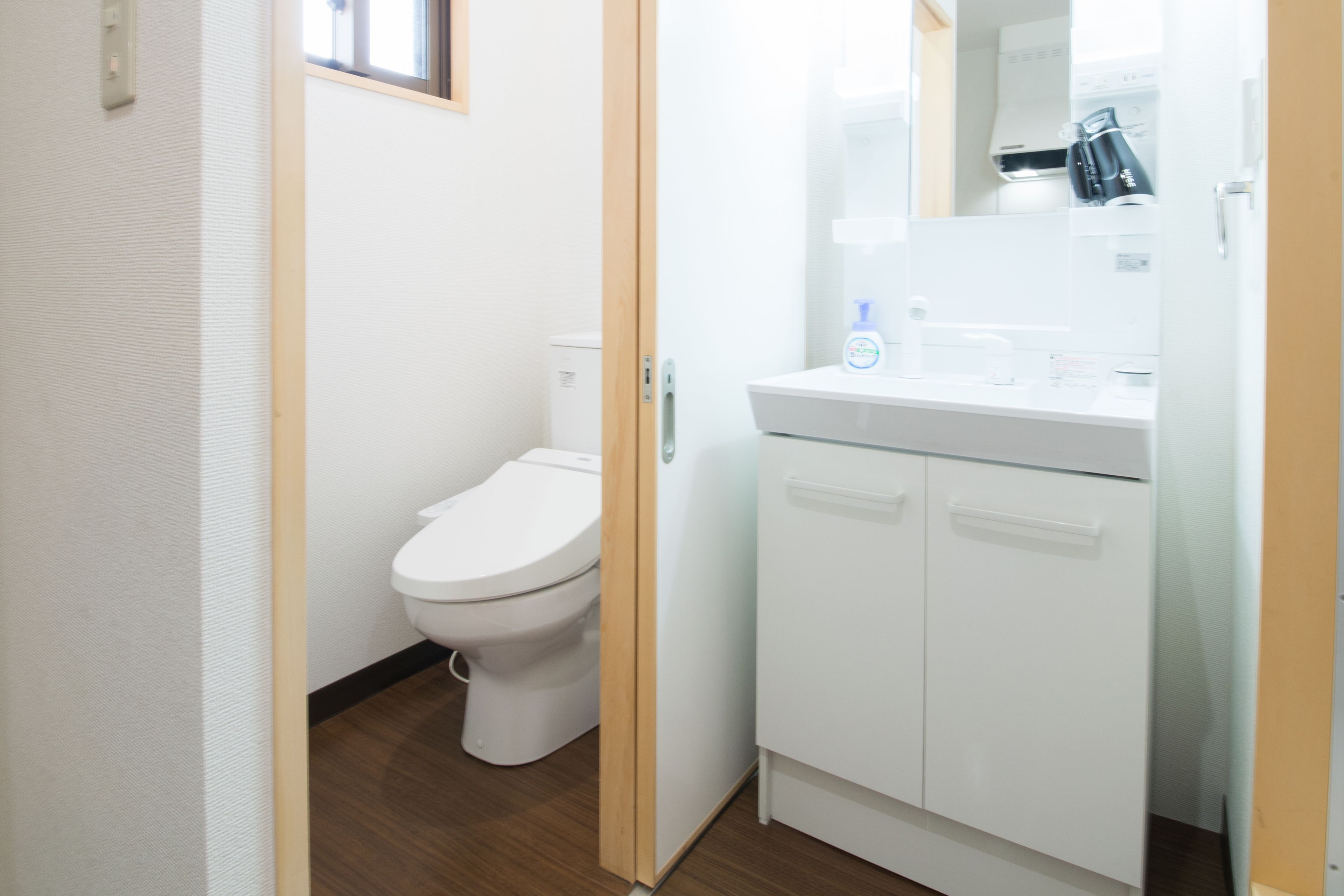 A small, modern bathroom with a toilet, a sink, and a mirror.