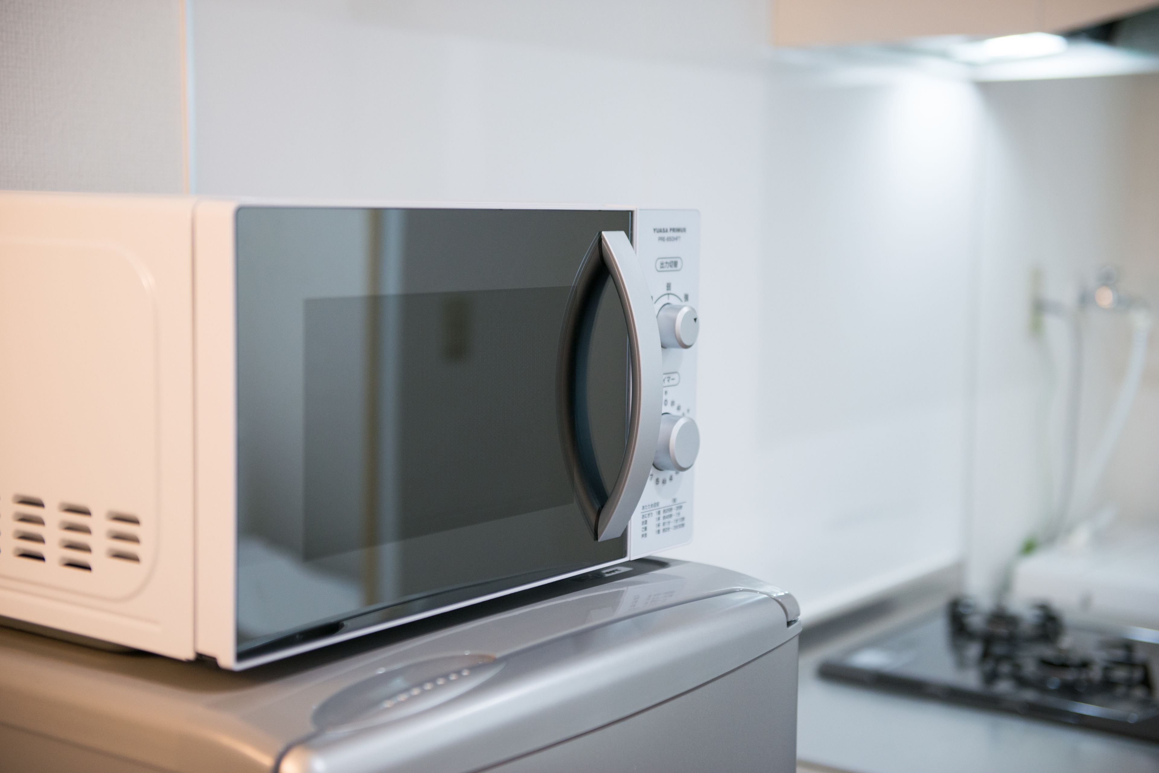 A microwave oven with a digital display and control panel, placed on a kitchen counter.