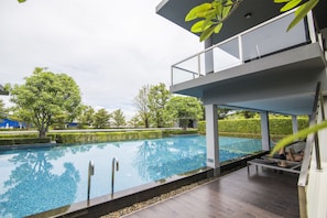 A modern pool area with a clear view of the pool, lounge chairs, and a covered seating area. - Maximum Land & House with WiFi (Udon Thani)
