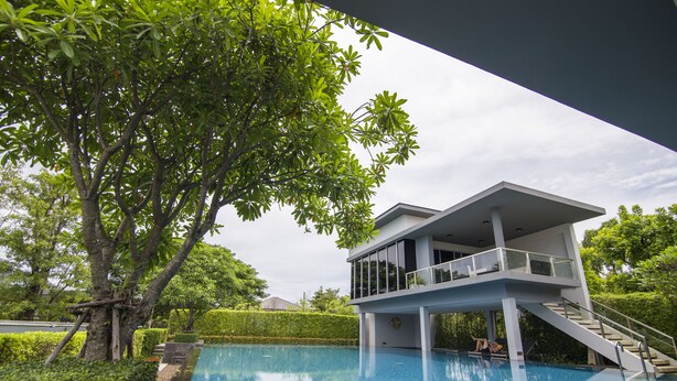 A modern house with a pool, surrounded by lush greenery. - Maximum Land & House with WiFi (Udon Thani)