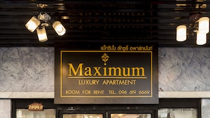 A luxury apartment building with a sign reading "Maximum Luxury Apartment" and a contact number. - Maximum Luxury Apartment (Udon Thani)