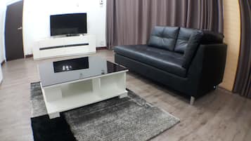 Habitación individual Confort, 1 cama de matrimonio grande, vistas a la ciudad | Zona de estar | Televisión de pantalla plana de 55 pulgadas con canales por cable