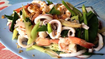 A plate of seafood salad with shrimp, squid, and vegetables.
