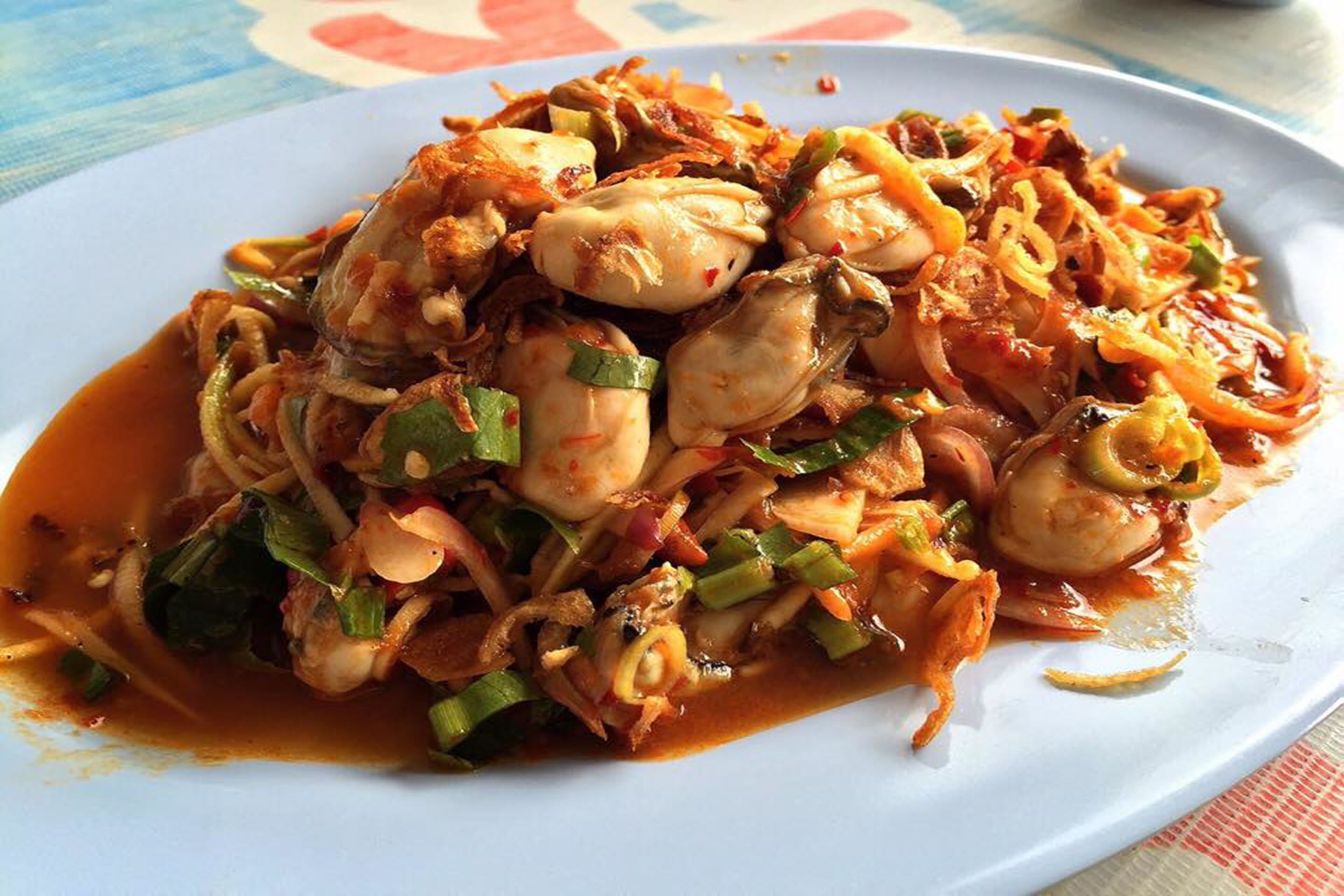 A plate of stir-fried seafood with vegetables and a spicy sauce.