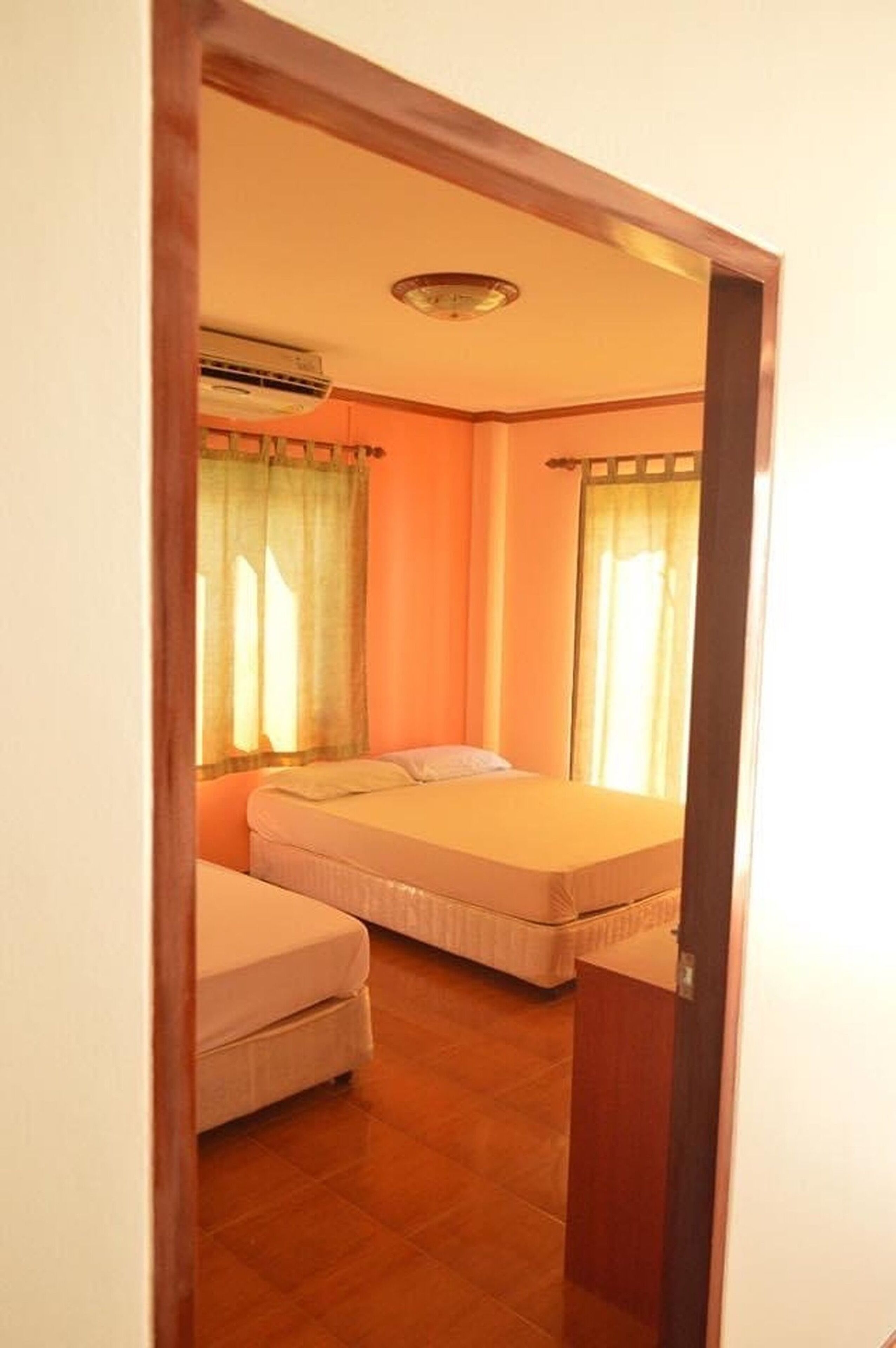 Un dormitorio con una cama, una mesita de noche y una ventana con cortinas.