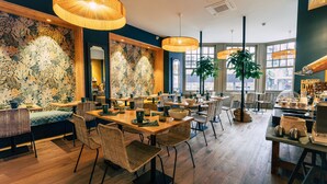 A restaurant with wooden tables, wicker chairs, and hanging lamps. - Hôtel Saint Julien (Angers)