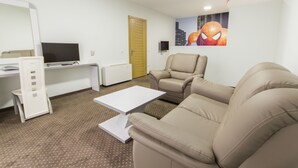 Ein modernes Wohnzimmer mit einer Couch, einem Couchtisch, einem Fernseher und einer Tür.