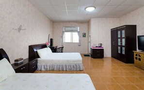 A bedroom with two beds, a desk, a wardrobe, a television, and a window. - Kaotai B&B (Luye)