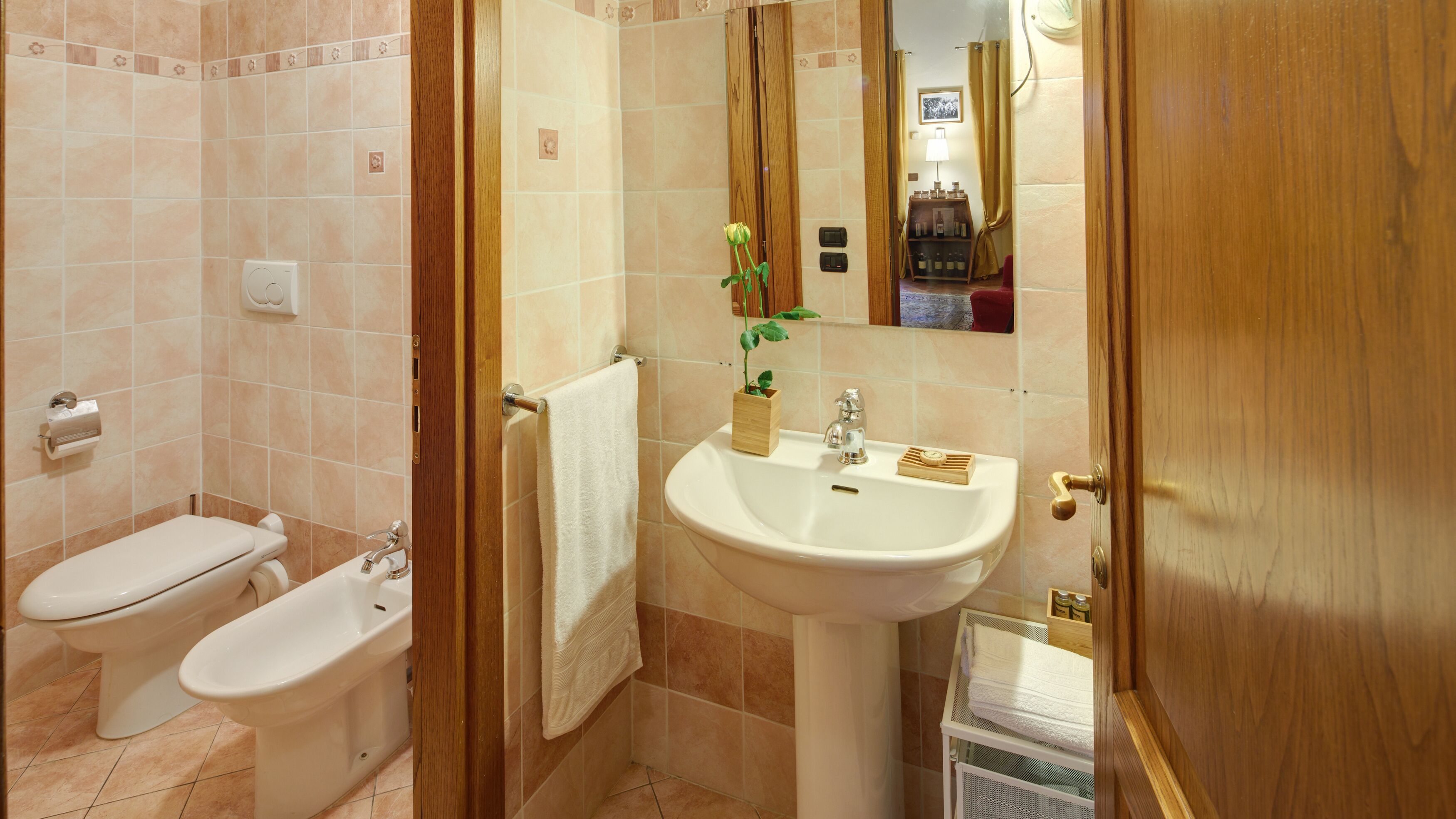 Ein Badezimmer mit Toilette, Bidet, Waschbecken und Spiegel.