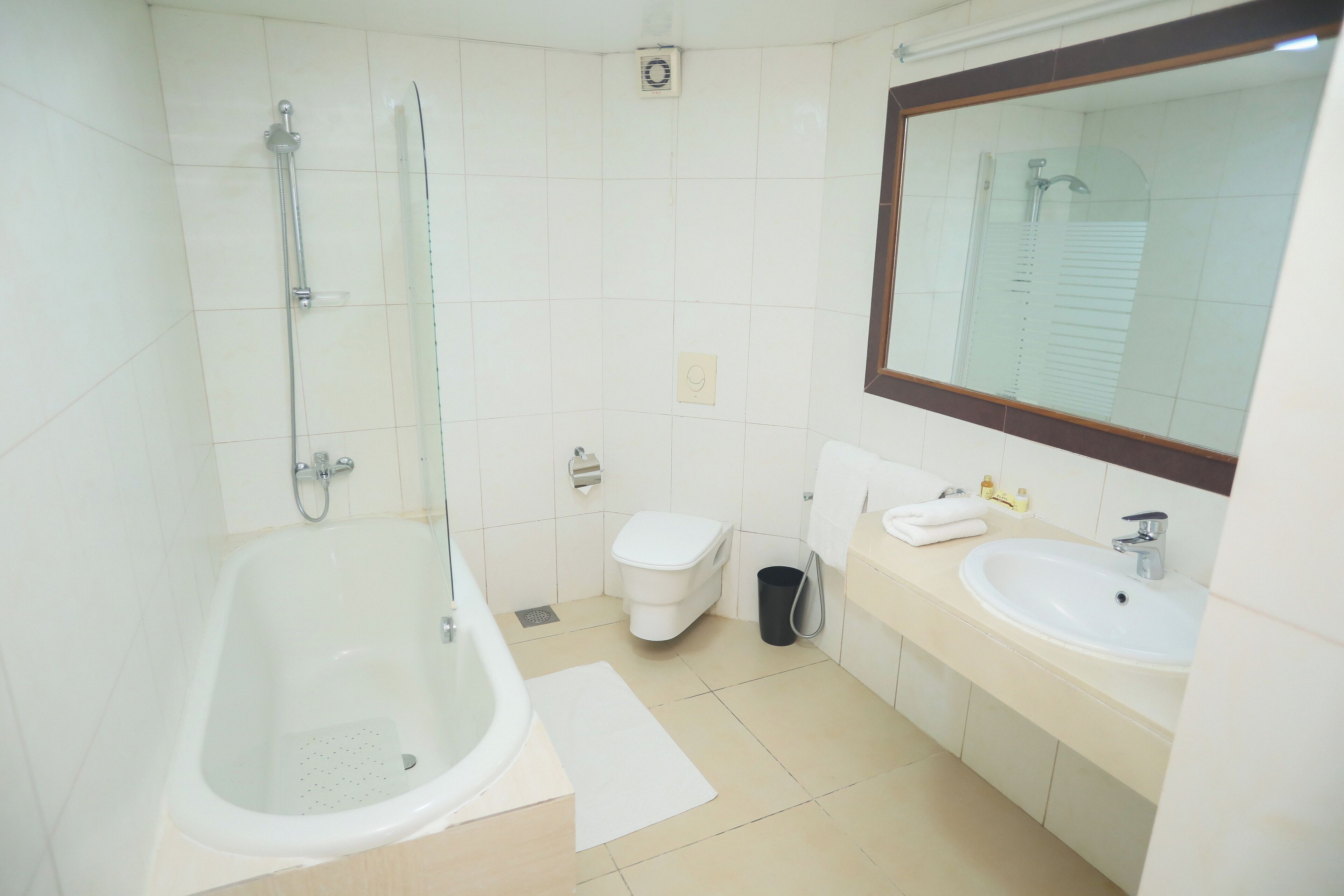 Un baño con bañera, inodoro, lavabo y espejo.