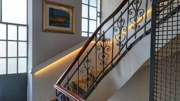 Una escalera con barandillas de metal decoradas y un suelo con estampado.