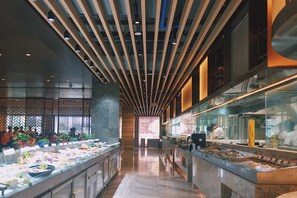 En buffetafdeling med en lang buffetbod, loftsbelysning og moderne indretning.