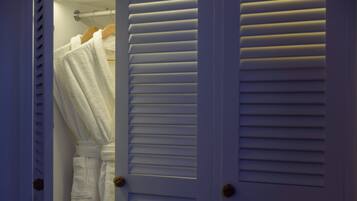 A white door with horizontal louvered panels and a wooden handle.