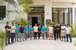Un grupo de personas de pie frente a un edificio con un letrero que dice "VELANA BEACH".