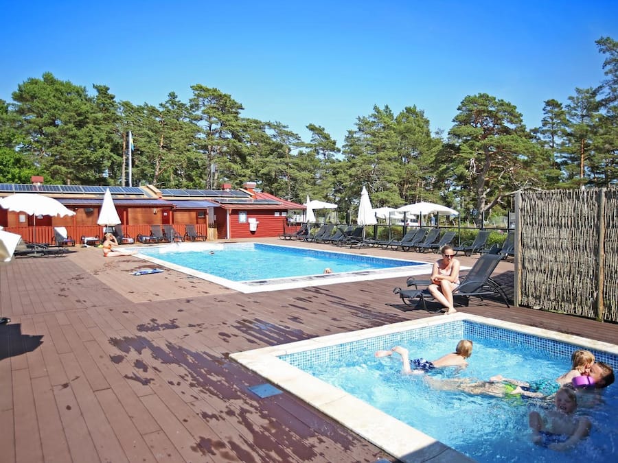 Una piscina al aire libre, sillones reclinables de piscina