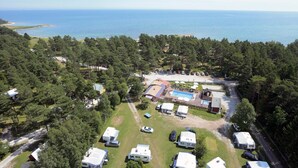 An aerial view of a campground with RVs, a swimming pool, and a beach in the background. - Ljugarn Semesterby (Ljugarn)