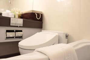 A modern bathroom with a toilet, a towel, and a shelf with toiletries.