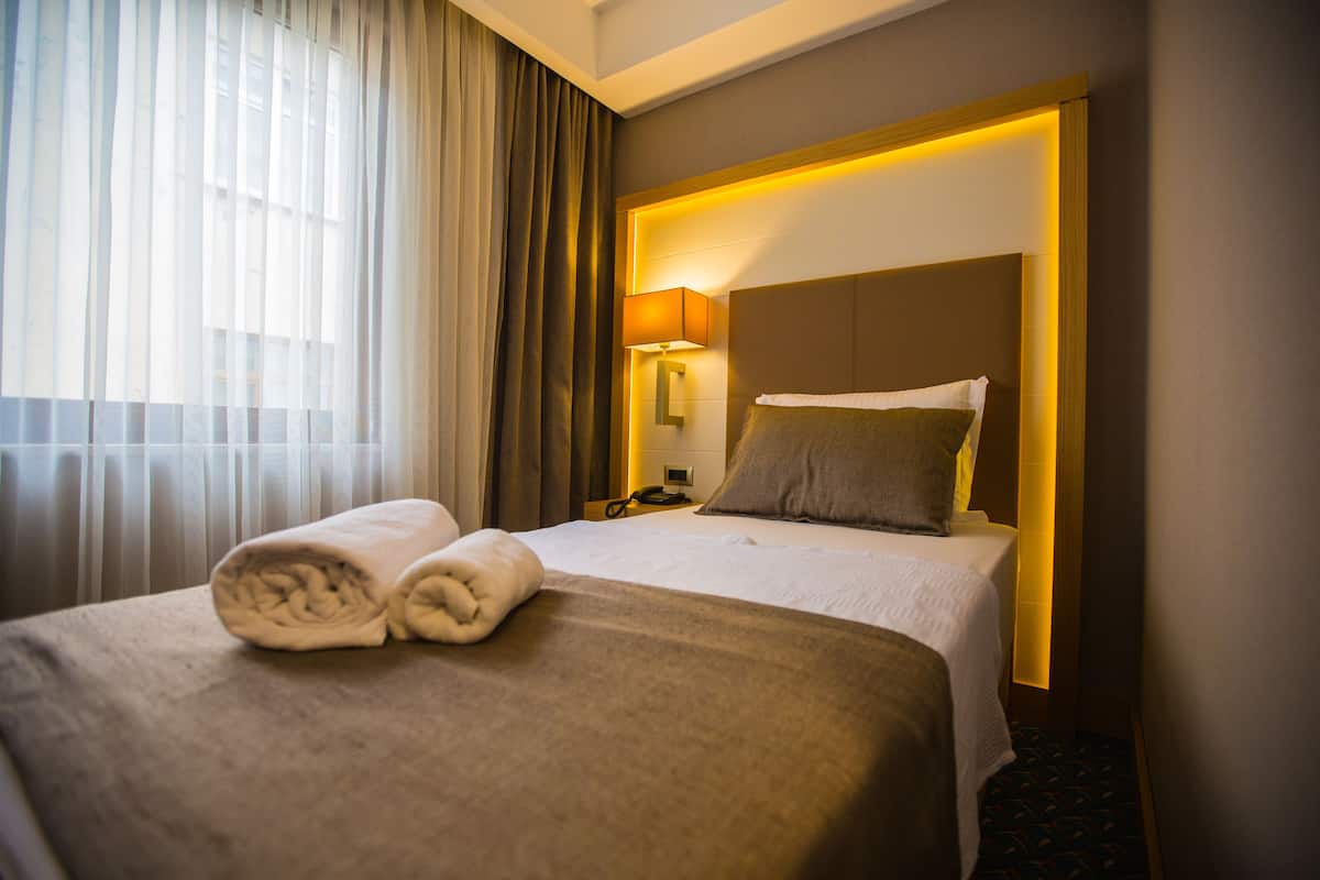 Standaard eenpersoonskamer | Luxe beddengoed, een minibar, een kluis op de kamer, een bureau