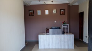 Un mostrador de recepción de diseño moderno, un reloj y certificados enmarcados en la pared.