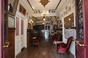 A room with wooden flooring, red upholstered chairs, a chandelier, and a ceiling fan. - Yeşilköy Airport Butik Otel (Istanbul)