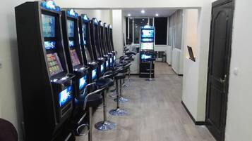 A row of arcade machines labeled 'Atlantis' in a hallway with bar stools.