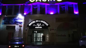 Un bâtiment sur lequel on peut voir une grande enseigne « CASINO » et une enseigne indiquant la réception de l’« HÔTEL DE L’AVENUE ».