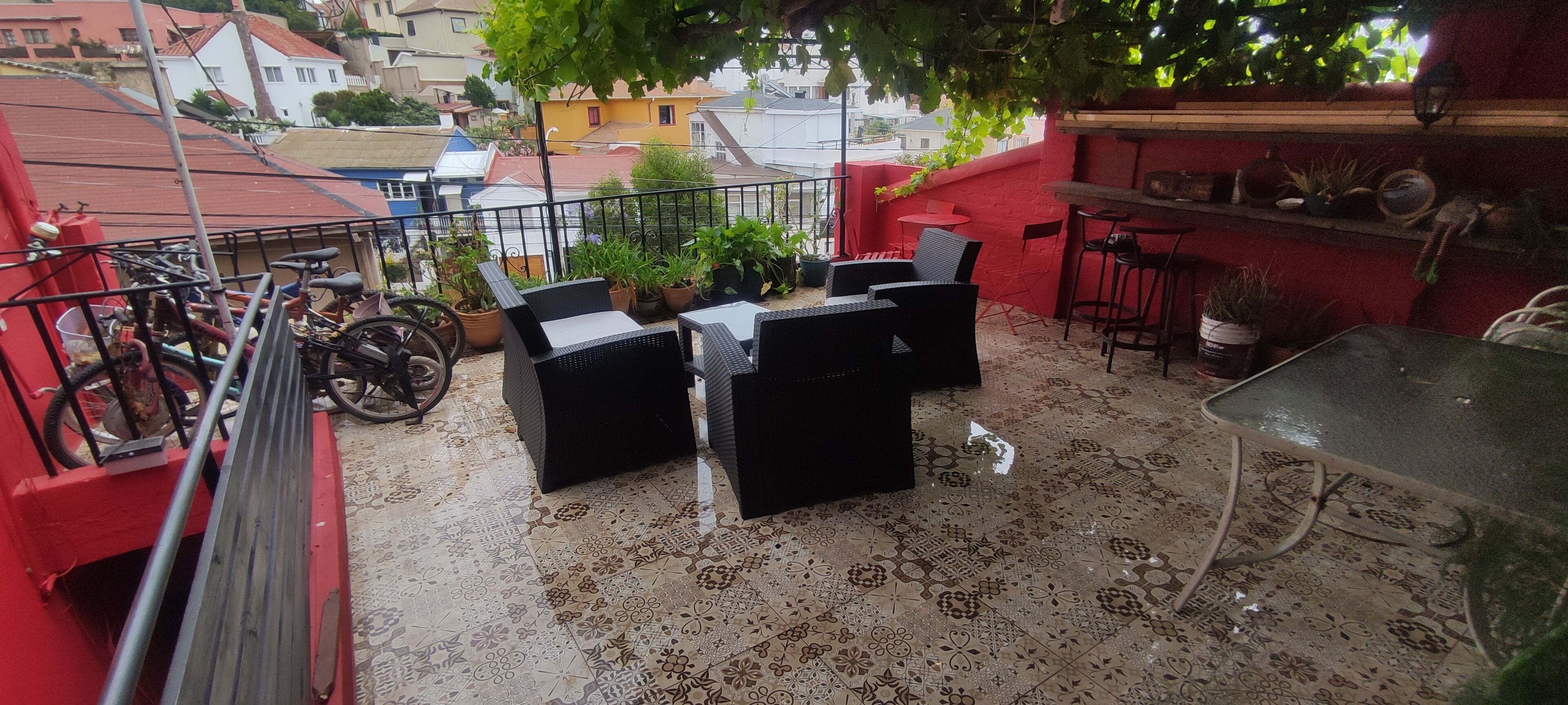 A balcony with outdoor furniture, potted plants, and a bicycle.