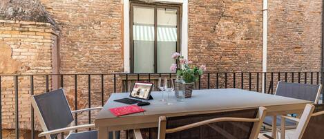 Un espacio al aire libre con una mesa, sillas y una computadora portátil.