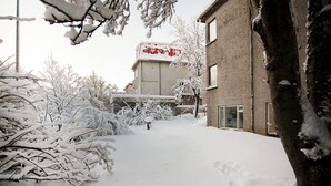 Een besneeuwde pad dat naar een gebouw leidt, met een rode bord.