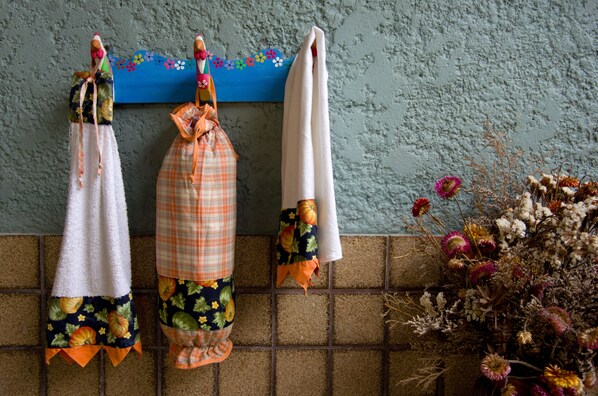 A wall with three hanging towels, each with a different pattern and color.