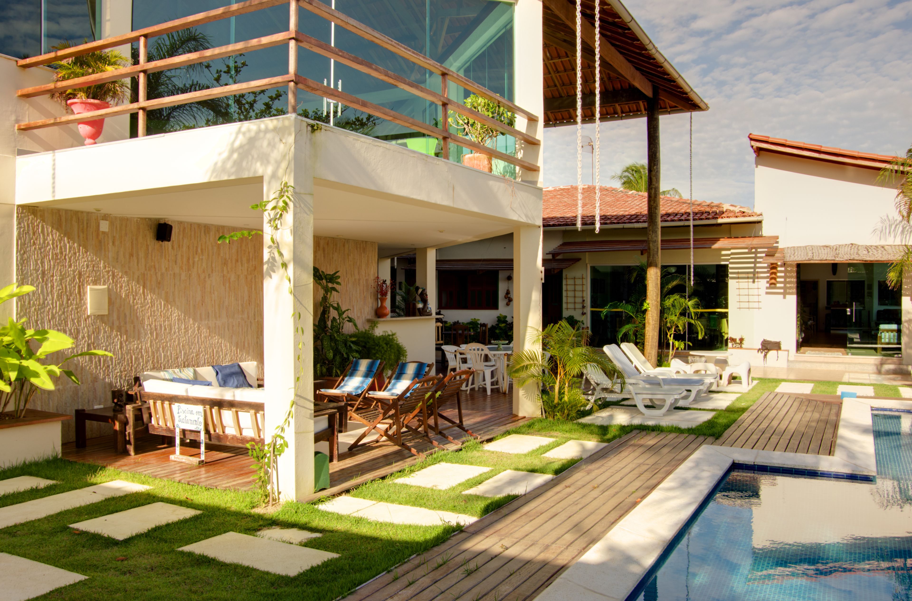 Una piscina al aire libre, sillones reclinables de piscina