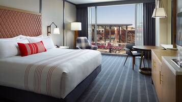 Une chambre d’hôtel avec un grand lit, un bureau, une chaise et une vue sur la ville.