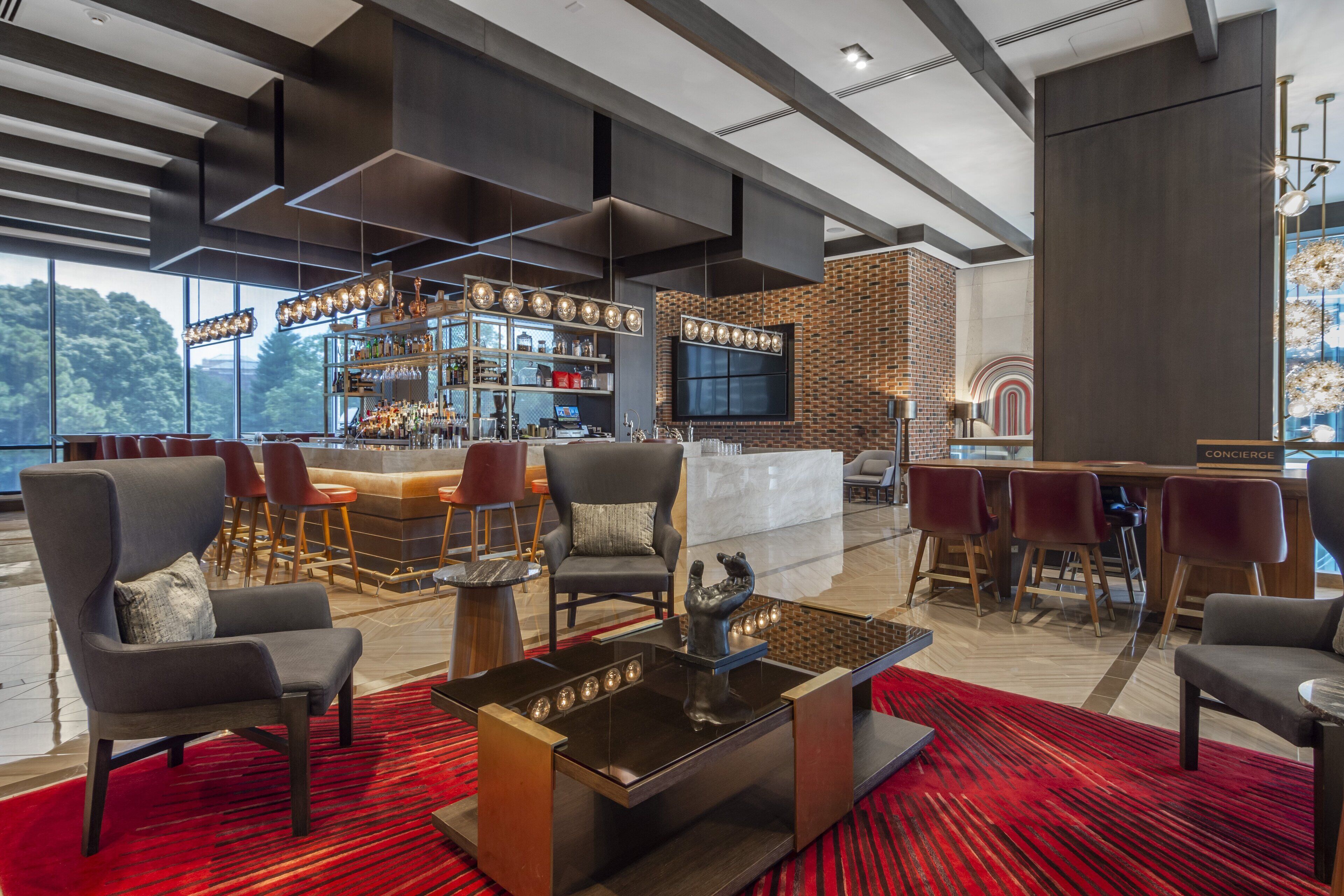 A modern bar area with a bar counter, seating, and a large screen.