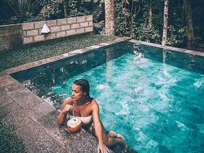 Una piscina al aire libre, sillones reclinables de piscina