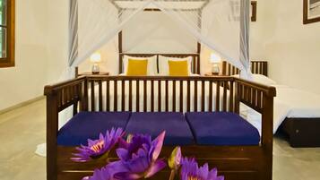A bed with a canopy, a bedside table with a lamp, and a purple cushion.