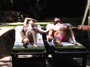 Una piscina al aire libre, sillones reclinables de piscina